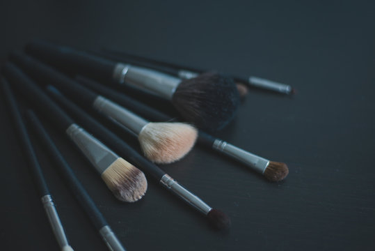 Makeup brushes on dark background spread out by fan, professional makeup  brushes, makeup brushes set on black background (horizontally; toned for  adding text). Stock Photo | Adobe Stock