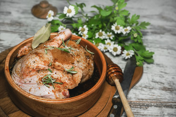 Duck legs cooked in a marinade with rosemary in the bowl of an olive tree