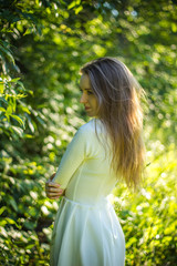 Beautiful girl in white dress on the leaves background. Natural beauty concept.