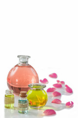 Rose flower petals with aromatherapy essential oil glass bottle isolated over white , background, copy-space