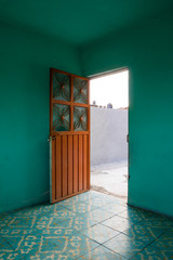 Blue room with orange steel door open to the outdoors