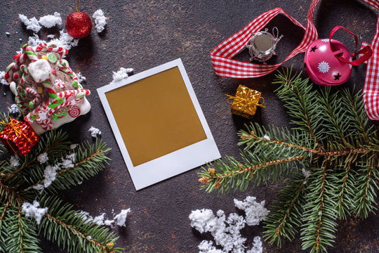 Christmas greeting card or photo frame over wooden table with snow fir tree.