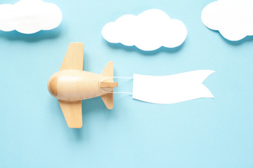 Children's wooden plane in the sky carries an empty banner.