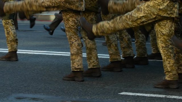 Soldiers in camo uniform marching in cadence at an army parade