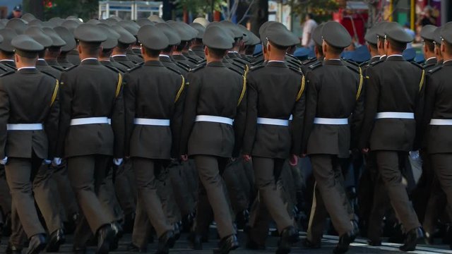 Ranks of soldiers marching at street