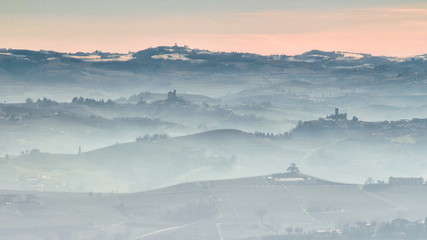 View of Langhe hills with vineyards in a foggy day from Verduno, Barolo area, Piedmont, Italy