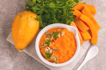 Bright tasty pureed pumpkin soup with ingredients