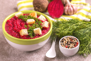 Bright tasty pureed beetroot soup with ingredients. Healthy food