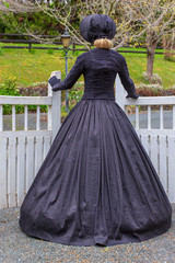 Fototapeta premium Victorian woman in black ensemble outdoors