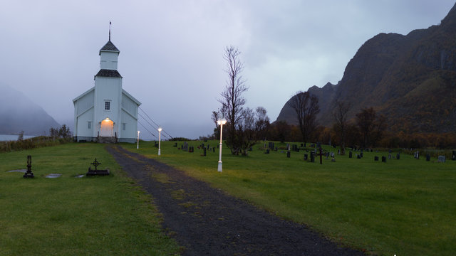 Gimsoy church lit up during dark autumn hours, Lofoten, Norway