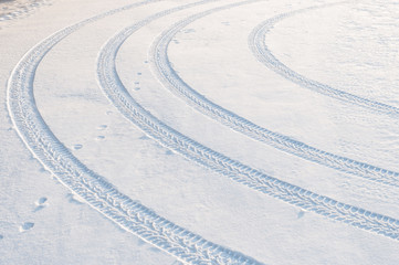 Car tire tracks in fresh snow.