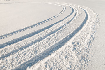 Car tire tracks in fresh snow.