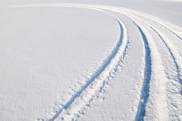 Car tire tracks in fresh snow.