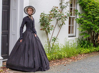 Victorian woman in black ensemble outdoors