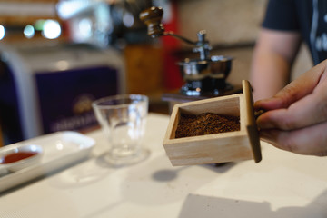Fototapeta na wymiar Hand crushing beans with coffee grinder