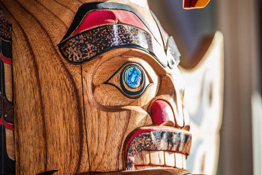 Totem sculpture art on wood pole in Alaska.