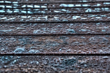 Water beads on stained wood