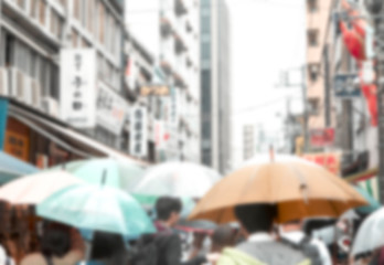 Blurred People holding umbrellas the street