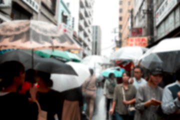 Fototapeta premium Blurred People holding umbrellas the street