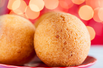 Traditional Colombian bunuelos (Deep Fried Cheese Bread) on christmas red background