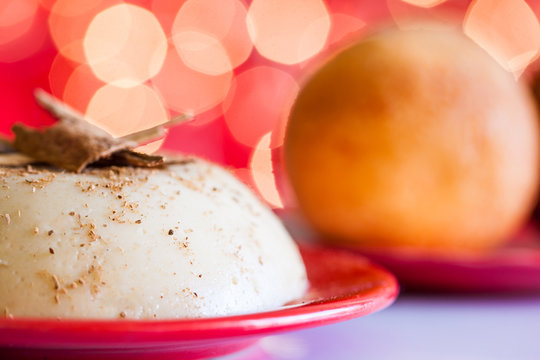 Traditional Colombian bunuelos (Deep Fried Cheese Bread) and natilla on christmas red background