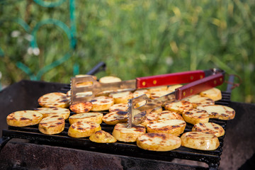 Картофель порезанный кружечками жарится на решетке.Горизонтально.