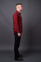 Full length profile view of young handsome man standing