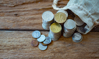 Us dollar,  euro and chinese yuan coins in sack and stacked, lay on real wooden plank.