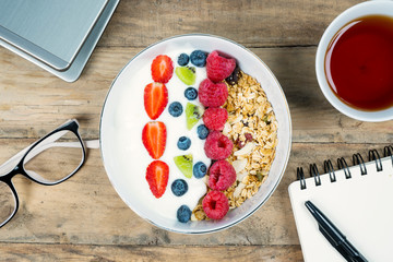 Business breakfast with yogurt and tea on desk