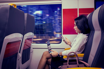 Female works with laptop and phone in train