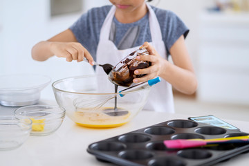 Obraz na płótnie Canvas Little girl making cookie dough in kitchen