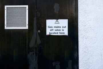 Gas valve main location plan safety sign on boiler house door with air grille