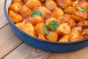 Baked potatoes with sweet paprika (red sweet pepper) on wooden table