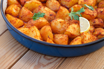 Baked potatoes with red sweet pepper (sweet paprika) on wooden table