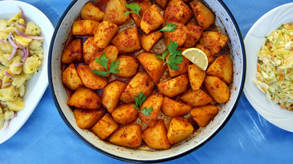 Baked potatoes with red sweet pepper on the middle with salads on sides