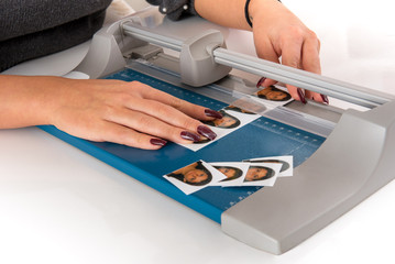 Woman cutting and sizing passport photos - obrazy, fototapety, plakaty