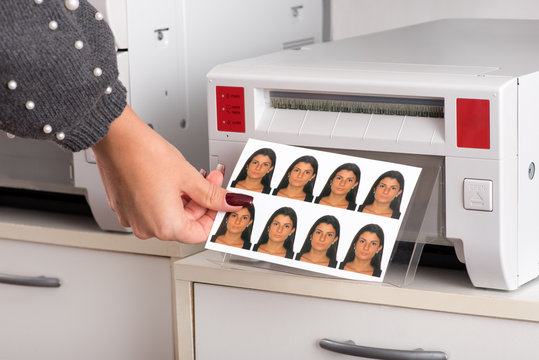 Just printed passport photos exiting a printer