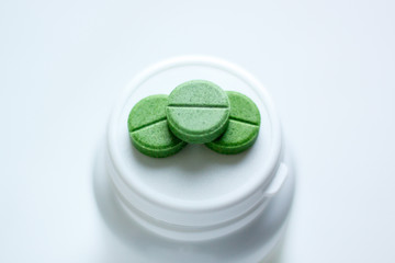 three pills on the lid of a medicine jar. selective focus