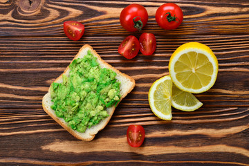 Obraz na płótnie Canvas Avocado sandwich on a bread made with fresh sliced avocados from above