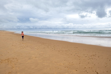 Active sporty woman run along sunset ocean beach. Sports background
