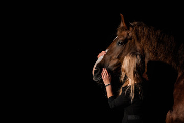girl hugging a horse on a dark background
