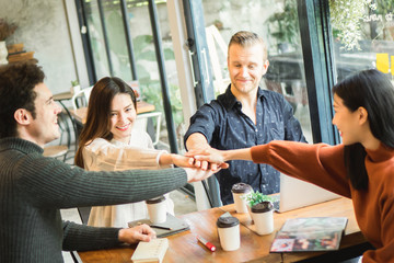 Young businessman and woman meeting in café and stack up for new target