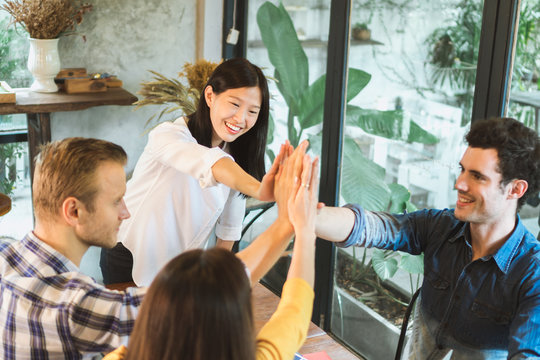 Young businessman and woman meeting in café and stack up for new target