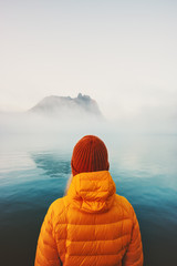 Traveler alone looking at foggy sea traveling adventure lifestyle outdoor solitude emotions winter...