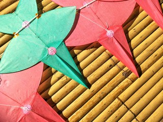Sunlight on surface of star-shaped kites on bamboo litter floor in Thai art of craft concept, high angle view with copy space