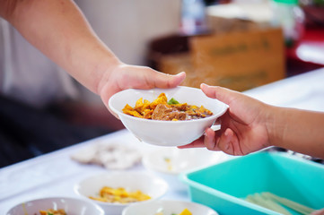 The hands of beggars offer food from the donor : The life of the poor