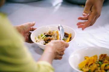 The hands of beggars offer food from the donor : The life of the poor