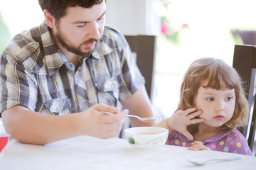 Cute little girl doesn't want to eat. Kid refusing food. Sad child