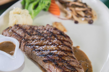 Grilled beef steak on white disc
