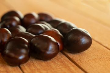 a small amount of chestnuts lying on a wooden plank surface